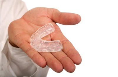man holding mouthguard in hand