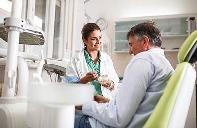 Dentist smiling at patient while reviewing treatment options