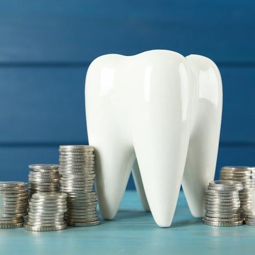 a tooth surrounded by coins portraying dental implant cost
