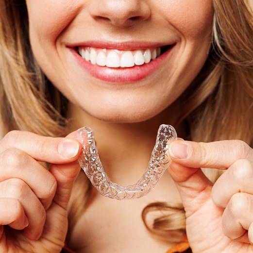 woman smiling with Invisalign tray
