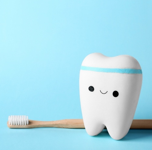 Animated tooth wearing a sweatband next to a wooden toothbrush