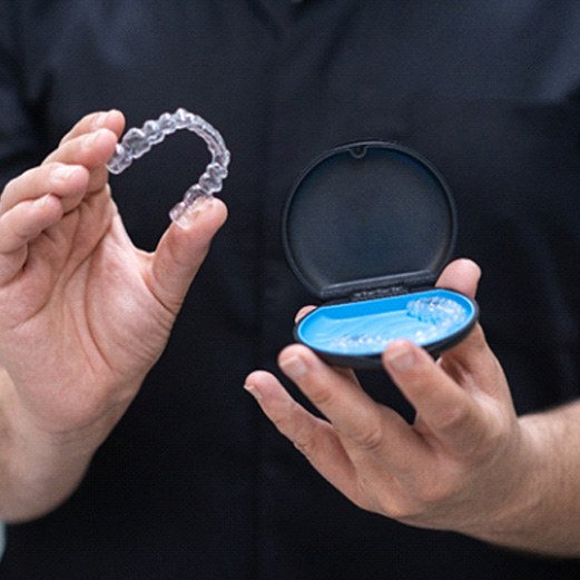 Closeup of patient holding clear aligner and clear aligner case