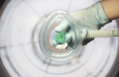 Gloved hand holding a sedation dentistry mask