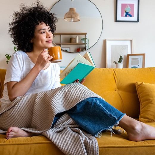 Young woman relaxing on couch after getting dental implants