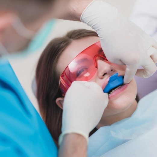 Young woman receiving fluoride treatment during preventive dentistry visit