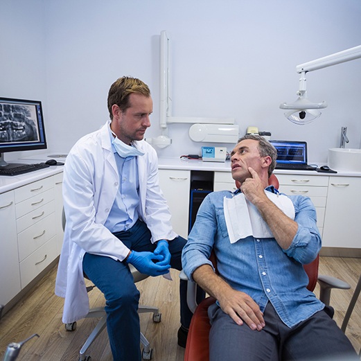 Male patient talking to dentist about dental implant