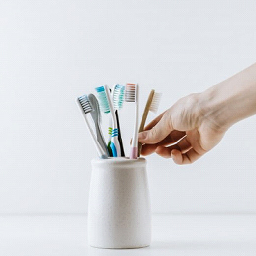 person reached for toothbrush in holder